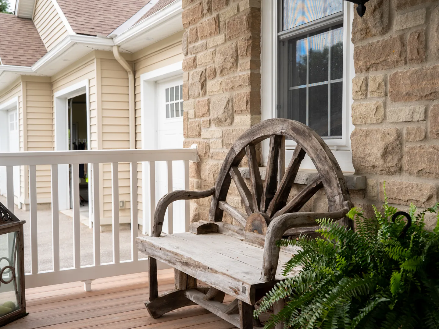 Wagon-wheel bench against a stone porch wall