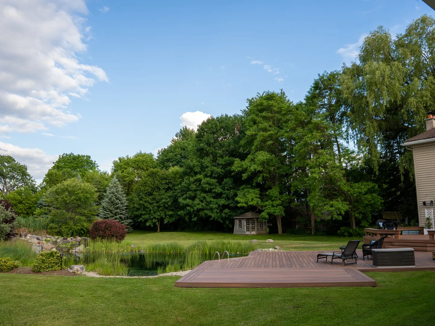 Wide view across the lawn, deck and pond