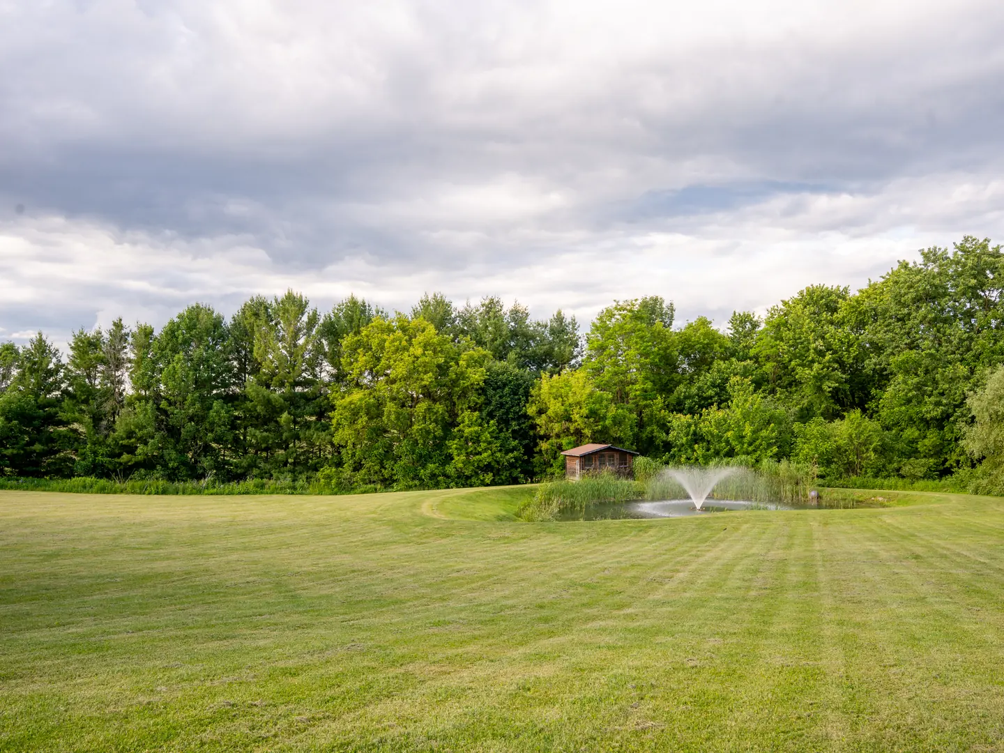 Broad lawn leading toward the pond and fountain
