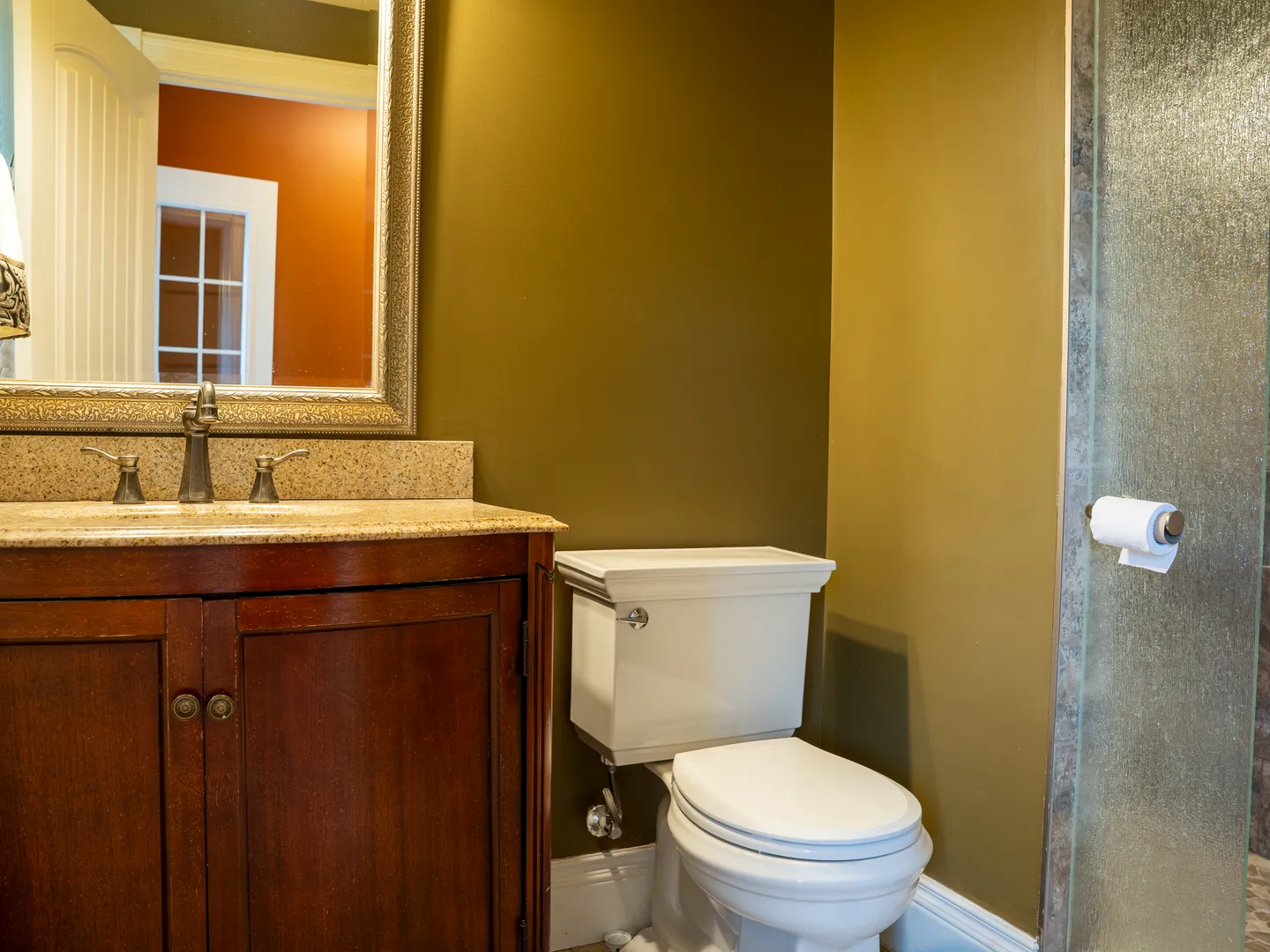 Powder room with a granite-top vanity and glass shower door