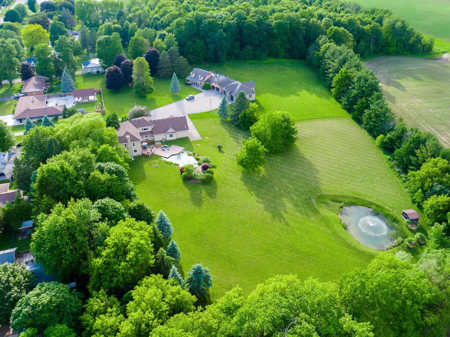 Wide aerial view of the house, grounds and water features