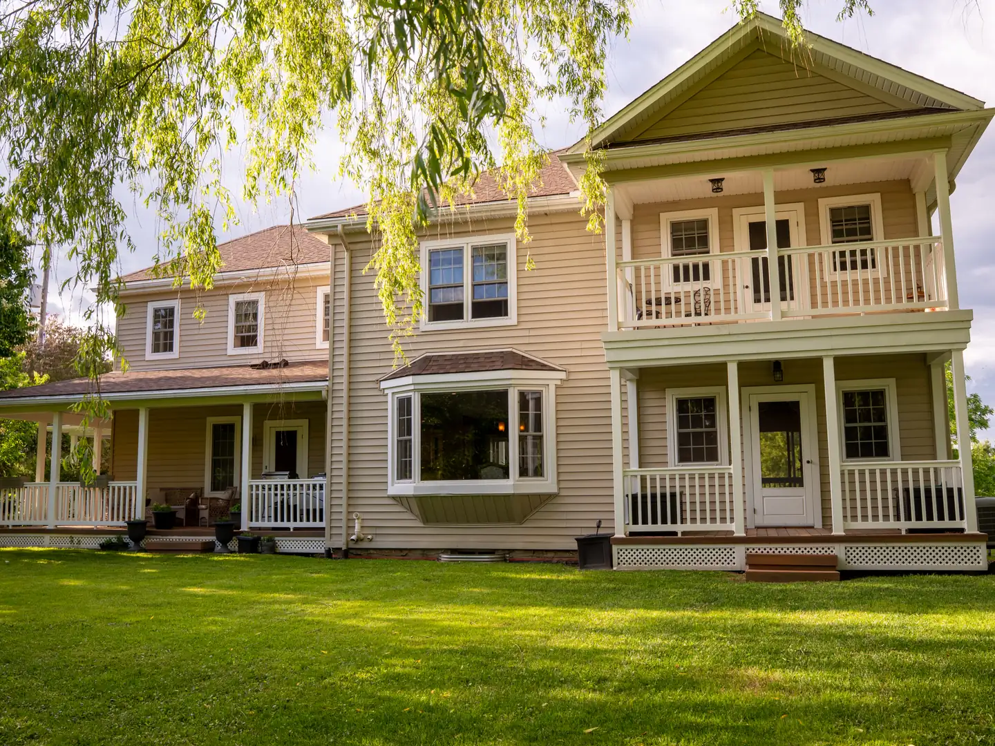 Rear elevation with covered porches and upper balcony.